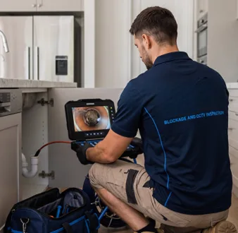 Plumber clearing a blocked toilet in a Balmain East bathroom